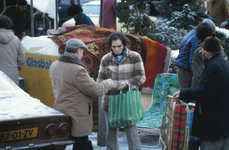851895 Afbeelding van een enkele verkopers en bezoekers op de rommelmarkt, gehouden op een besneeuwd braakliggend ...
